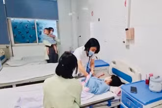 Bác sĩ bệnh viện Thanh Nhàn, Hà Nội thăm khám cho trẻ mắc sởi đang điều trị tại khoa Nhi của Bệnh viện. (Ảnh: ĐỖ THOA)