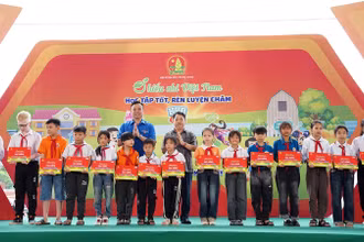 Phó Chủ tịch Hội đồng Đội Trung ương, Giám đốc Trung tâm Hỗ trợ và Phát triển thiếu nhi Việt Nam Lê Anh Quân (bên trái, hàng sau) cùng đại diện Ban tổ chức Ngày hội trao học bổng tặng thiếu nhi hoàn cảnh khó khăn.
