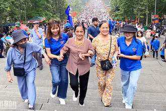 Tình nguyện viên hỗ trợ du khách cao tuổi trên đường lên Đền Hùng. 