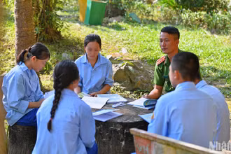 Đại úy Trần Đại Lượng ôn lại bài tập cùng học sinh trong khuôn viên trường.