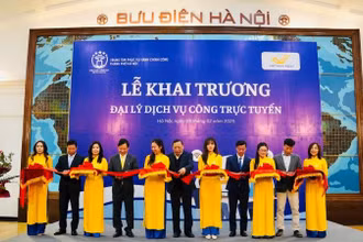 Các đại biểu thực hiện nghi thức khai trương đại lý dịch vụ công trực tuyến tại số 75 phố Đinh Tiên Hoàng (quận Hoàn Kiếm). (Ảnh: T.Hà)