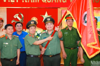 Lãnh đạo Công an thành phố trao cờ cho tuổi trẻ Công an Thành phố trong lễ ra mắt công trình thanh niên.