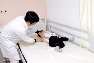 Khám cho trẻ cong vẹo cột sống.
