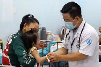 Bác sĩ Bệnh viện Nhi đồng 1 TP Hồ Chí Minh thăm khám cho trẻ mắc tay chân miệng. (Ảnh: THẾ ANH)