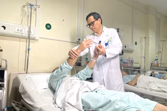 Phó Giáo sư, Tiến sĩ Đồng Văn Hệ thăm khám cho bệnh nhân sau phẫu thuật.