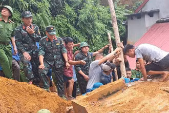 Lực lượng cứu hộ và người dân khẩn trương cứu hộ anh Lương Văn Ba bị mắc kẹt do sạt lở đất. (Ảnh: HẢI CHUNG)