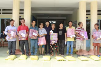 Lãnh đạo huyện Long Hồ và các nhà hảo tâm hỗ trợ tiền, quà cho người dân có nhà đất bị sạt lở.