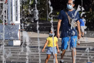 Người dân đi ngang qua đài phun nước vào một ngày hè nóng nực ở Hong Kong, Trung Quốc. Ảnh: Tân Hoa xã