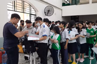 Các thí sinh làm thủ tục gửi đồ tại khu vực gửi đồ ở điểm thi Trường trung học phổ thông Lê Quý Đôn.