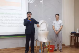 Ông Nguyễn Văn Nam (bên trái ảnh) thuyết trình về nguyên lý hoạt động của sáng chế hệ thống cơ-điện điều khiển bồn cầu xả nước.