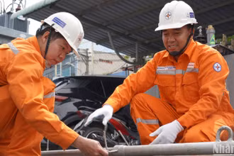 Anh Huỳnh Thanh Thuận (bìa phải) đang hướng dẫn sử dụng sáng kiến “Sào đỡ cáp ngầm”.