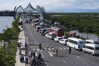 Ô tô chở khách du lịch tham quan đảo Cát Bà xếp hai hàng chạy dài hơn 1 km trên đường tỉnh 356 tại đầu bến Cái Viềng, chờ đến lượt xuống phà trở về đất liền. Ảnh : Báo Thanh Niên 