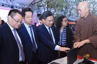 Các đại biểu tìm hiểu về kỹ thuật in cổ truyền tại Phố sách Xuân.
