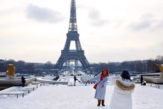 Khách du lịch chụp ảnh lưu niệm dưới chân tháp Eiffel. (Nguồn: TTXVN)