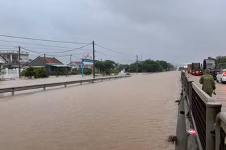 Nước ngập trên tuyến quốc lộ 1 đoạn qua xã an Mỹ, huyện Tuy An (Km1315), lực lượng chức năng điều tiết giao thông bảo đảm an toàn các phương tiện.