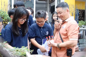 Anh Bùi Thanh Phú (ngoài cùng bên phải) giới thiệu với học sinh về nghề làm nước mắm.
