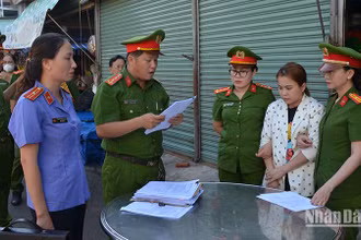 Cơ quan cảnh sát điều tra Công an thành phố Phan Thiết đọc Quyết định khởi tố bị can đối với Ngô Thị Loan Chi (áo trắng hoa), về tội “Lừa đảo chiếm đoạt tài sản”.