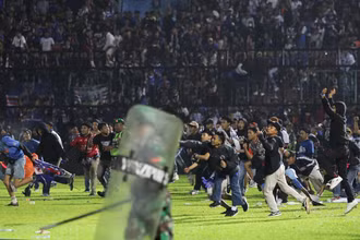 Các cổ động viên quá khích tràn vào sân vận động Kanjuruhan sau khi Arema FC để thua Persebaya với tỷ số 2-3 trong trận đấu tối 1/10/2022. (Ảnh: AP)