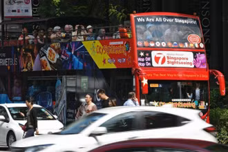 Xe buýt chở khách du lịch trên đường phố Singapore. (Ảnh: Xinhua)