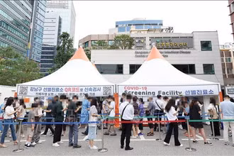 Người dân chờ xét nghiệm Covid-19 tại điểm xét nghiệm ở Seoul, Hàn Quốc, ngày 12/7/2022. (Ảnh: YONHAP/TTXVN)