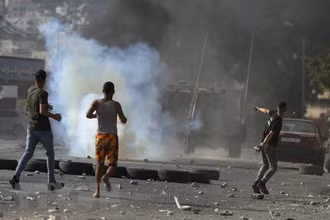 Người biểu tình Palestine ném đá trong cuộc xung đột với binh sĩ Israel tại thành phố Nablus, khu Bờ Tây, ngày 17/8/2022. (Ảnh: AFP/TTXVN)
