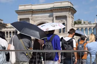 Người dân dùng ô để che nắng khi xếp hàng vào Nhà thờ Duomo trong đợt nắng nóng ở Milan, Italia, ngày 21/8/2023. (Ảnh: Reuters)