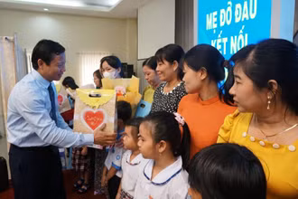 Lãnh đạo Ủy ban nhân dân tỉnh Long An trao hoa cho các mẹ đỡ đầu và quà cho trẻ mồ côi. 