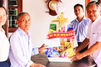 Bí thư Huyện ủy Gò Dầu Trịnh Ngọc Phương (phải) thăm và tặng quà Anh hùng Lực lượng vũ trang Phạm Văn Chiến nhân dịp kỷ niệm 50 năm Ngày Giải phóng miền nam, thống nhất đất nước.