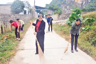 Bà Hoàng Thị Phượng cùng người dân trong thôn quét dọn, vệ sinh đường giao thông nông thôn.