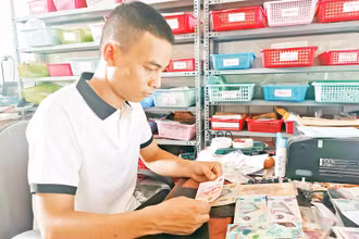 Anh Trần Văn Nam kiểm tra các tờ tiền. 