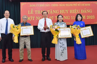 Đồng chí Nguyễn Văn Nên, Ủy viên Bộ Chính trị, Bí thư Thành ủy Thành phố Hồ Chí Minh và đồng chí Nguyễn Hồ Hải, Phó Bí thư Thành ủy chúc mừng đảng viên được nhận Huy hiệu Đảng.
