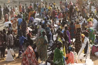 Người dân xếp hàng chờ nhận hàng cứu trợ tại Gedaref, Sudan. (Ảnh: AFP/TTXVN)
