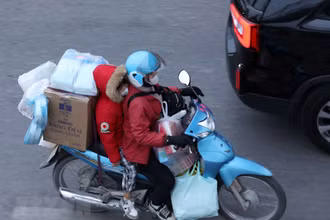 Dễ dàng bắt gặp chiếc xe máy chở cồng kềnh đồ đạc trên đường. (Ảnh: Hoàng Hiếu/TTXVN)