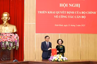 Thay mặt Bộ Chính trị, Ban Bí thư, đồng chí Trương Thị Mai, Ủy viên Bộ Chính trị, Thường trực Ban Bí thư, Trưởng Ban Tổ chức Trung ương trao quyết định và tặng hoa chúc mừng tân Bí thư Tỉnh ủy Ninh Bình Đoàn Minh Huấn. (Ảnh: Lê Hồng)