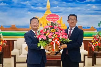 Đại sứ Nguyễn Minh Tâm chúc mừng Quyền Trưởng Ban Đối ngoại Trung ương Đảng Nhân dân Cách mạng Lào Bounlua Phandanouvong. (Ảnh: Cộng tác viên)
