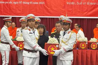 Các đại biểu thực hiện nghi lễ tiễn đưa hài cốt các liệt sĩ về nước. (Ảnh: HẢI TIẾN)