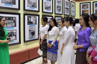 Sinh viên Việt-Lào nghe thuyết minh, giới thiệu ảnh về truyền thống hữu nghị Việt-Lào.