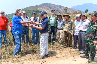 Cựu chiến binh Mỹ John Cimino trao lại chiếc ví kỷ vật của liệt sĩ Hoàng Quang Lợi cho Ban liên lạc tìm đồng đội Trung đoàn 209. (Ảnh: TRƯƠNG ĐỨC BÌNH)