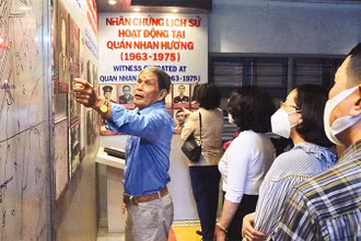 Du khách nghe giới thiệu về hoạt động của lực lượng biệt động Sài Gòn tại Nhan Hương quán, một điểm đến trong tour “Theo dấu chân biệt động Sài Gòn”. (Ảnh: HOÀNG TUYẾT)