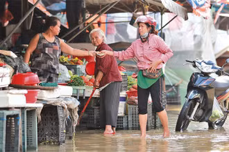 Tiểu thương chợ Hội An tranh thủ bán hàng sau cơn mưa.