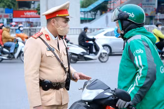 Cảnh sát giao thông Hà Nội nhắc nhở lái xe công nghệ chấp hành nghiêm Luật Giao thông đường bộ. (ảnh HUY HOÀNG)