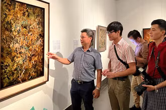 Họa sĩ Triệu Khắc Tiến giới thiệu tác phẩm sơn mài trên vóc “Hoan ca”. 