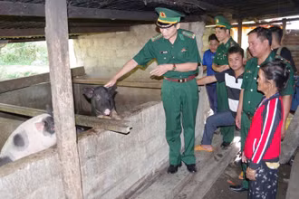 Đại tá Hoàng Văn Mẫn, Chính ủy Bộ Chỉ huy Bộ đội Biên phòng tỉnh Quảng Nam hướng dẫn hội viên phụ nữ vùng biên cách chăn nuôi lợn hiệu quả.