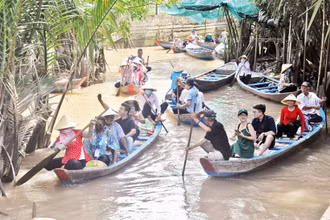 Chèo đò đưa du khách khám phá hệ thống kênh, rạch tại cù lao Thới Sơn, thành phố Mỹ Tho.