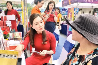 Cán bộ ngân hàng hướng dẫn người dân cách thanh toán không dùng tiền mặt.