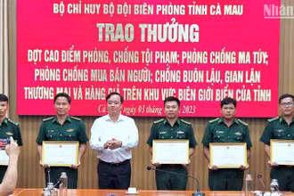 Chủ tịch Ủy ban nhân dân tỉnh Cà Mau Huỳnh Quốc Việt (áo trắng) tặng Bằng khen cho tập thể, cá nhân Biên phòng Cà Mau có thành tích tốt trong phá án về buôn lậu, ma túy.