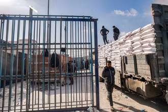 Bốc dỡ hàng viện trợ từ xe tải của UNRWA tại thành phố Rafah, Dải Gaza. (Ảnh: AFP/TTXVN)