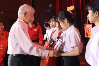 Nguyên Chủ tịch nước Nguyễn Minh Triết trao học bổng cho học sinh có hoàn cảnh khó khăn. 