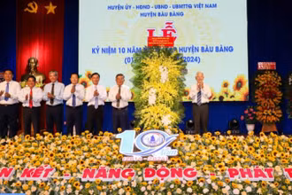 Nguyên Chủ tịch nước Nguyễn Minh Triết trao tặng lẵng hoa chúc mừng huyện Bàu Bàng. 