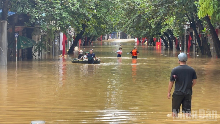 Nhiều người dân phường Yên Bái dùng thuyền để di chuyển qua đoạn nước dâng cao trên đường Thành Công. (Ảnh: THANH SƠN) ndo_br_img-7083.jpg